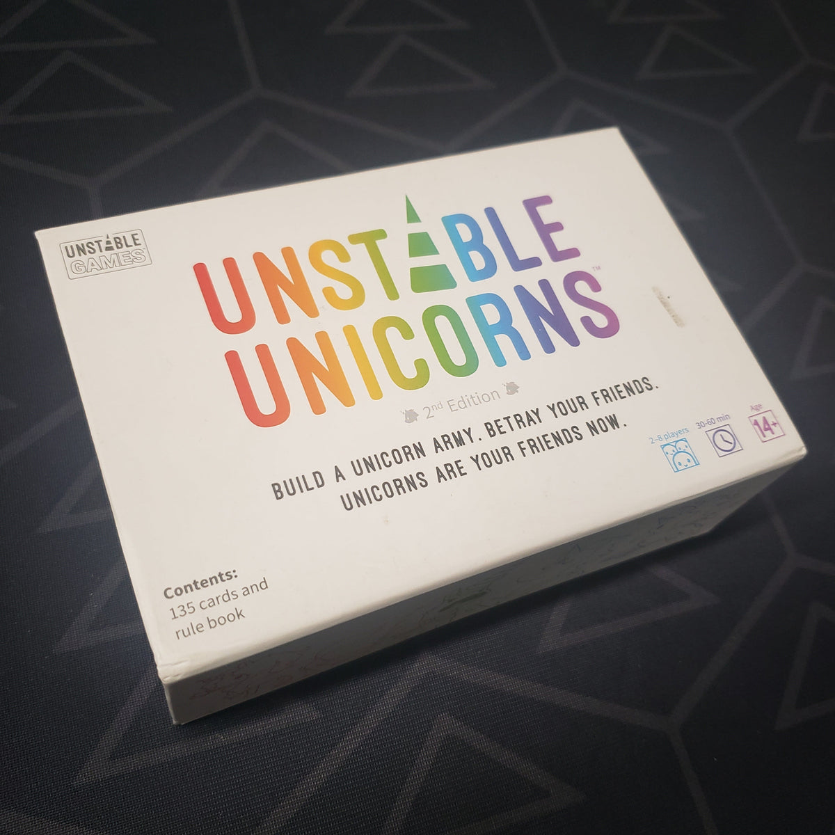 Image shows the front cover of the box of the Unstable Unicorns card game