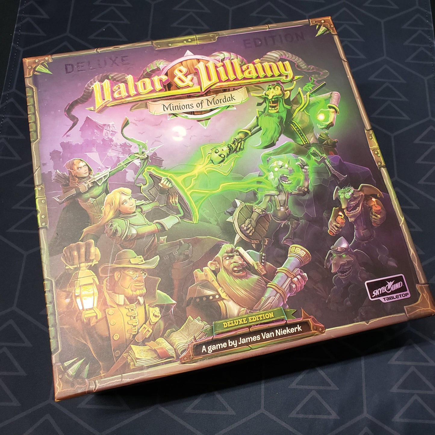 Image shows the front cover of the box for the Valor & Villainy: Minions of Mordak board game