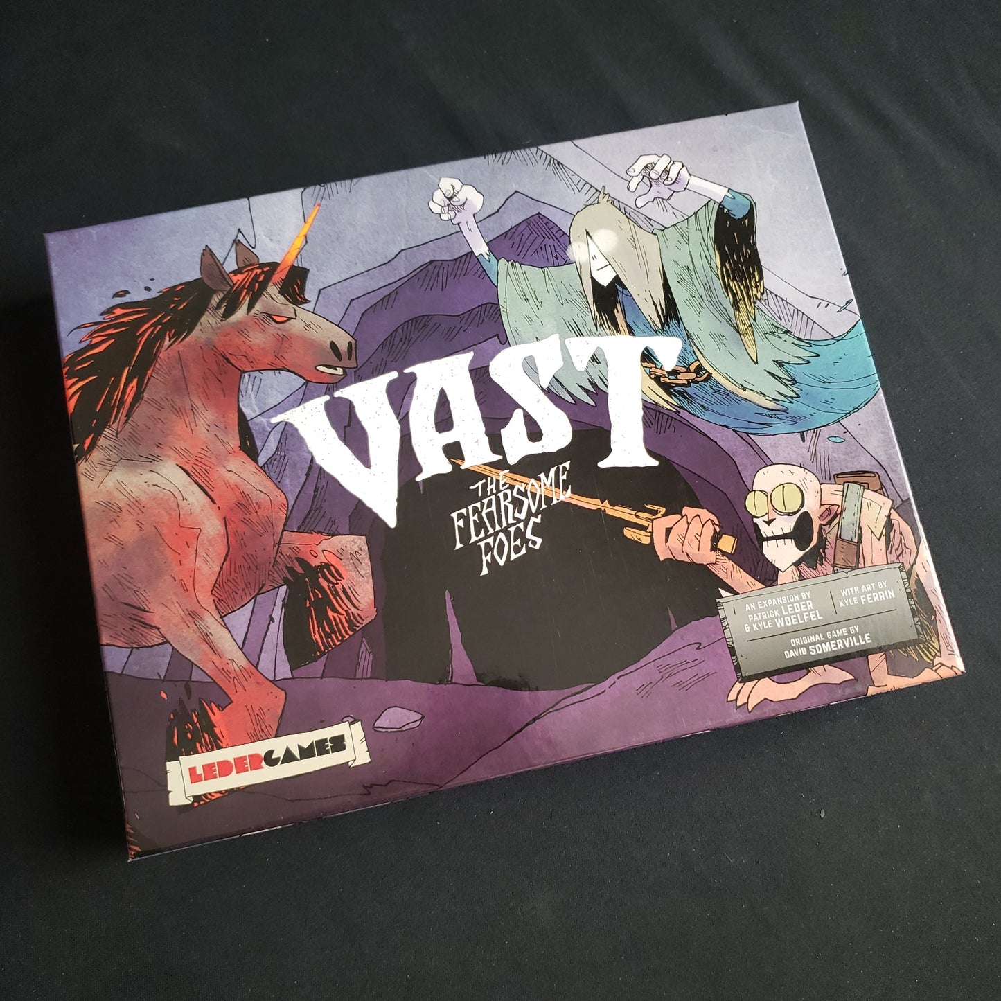 Image shows the front cover of the box of the Fearsome Foes expansion for the board game Vast: The Crystal Caverns