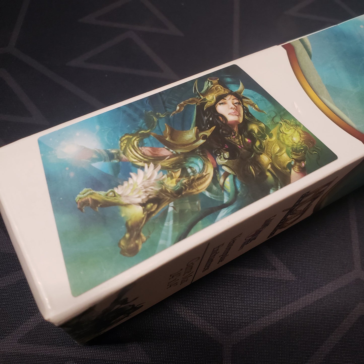 Image shows close-up of the art on the side of the box for the Venompulse Enchantress card game playmat
