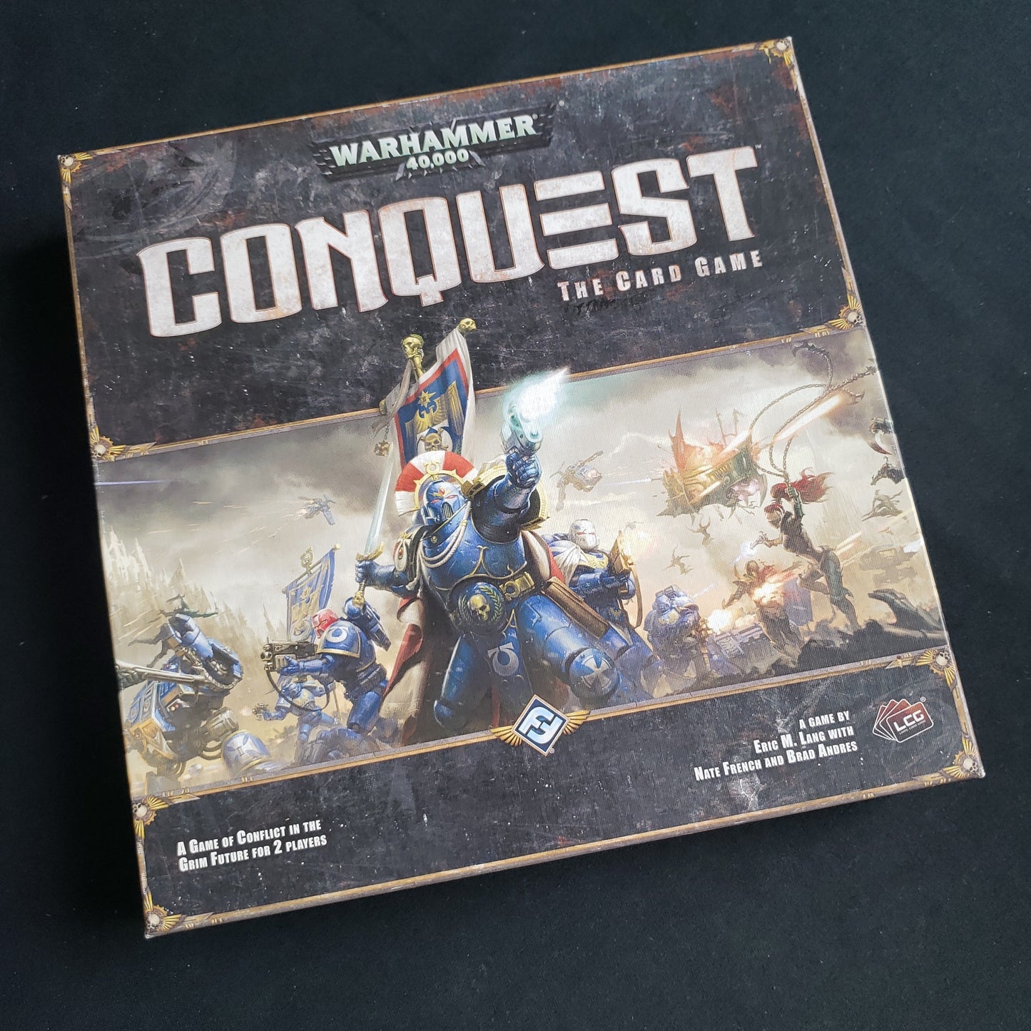 Image shows the front cover of the base set box for the card game Warhammer 40K: Conquest