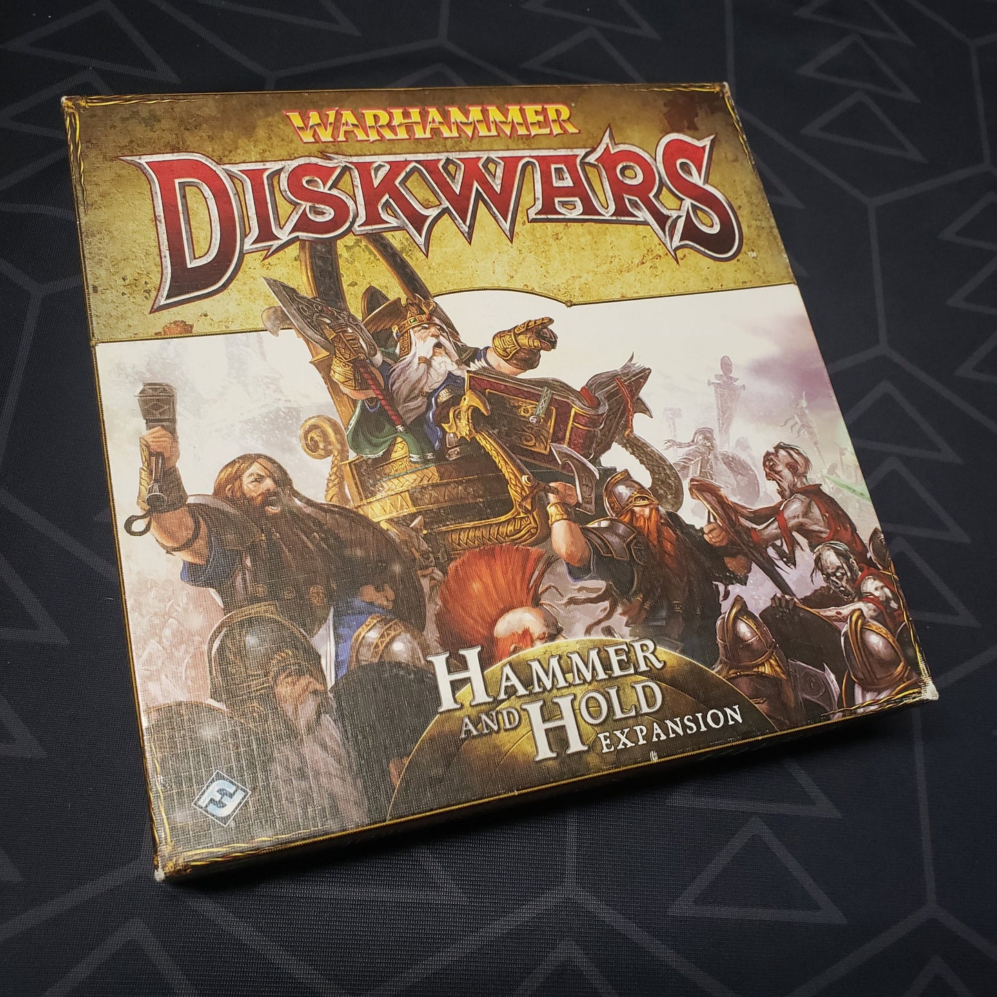 Image shows the front cover of the box of the Hammer and Hold expansion for the board game Warhammer Diskwars