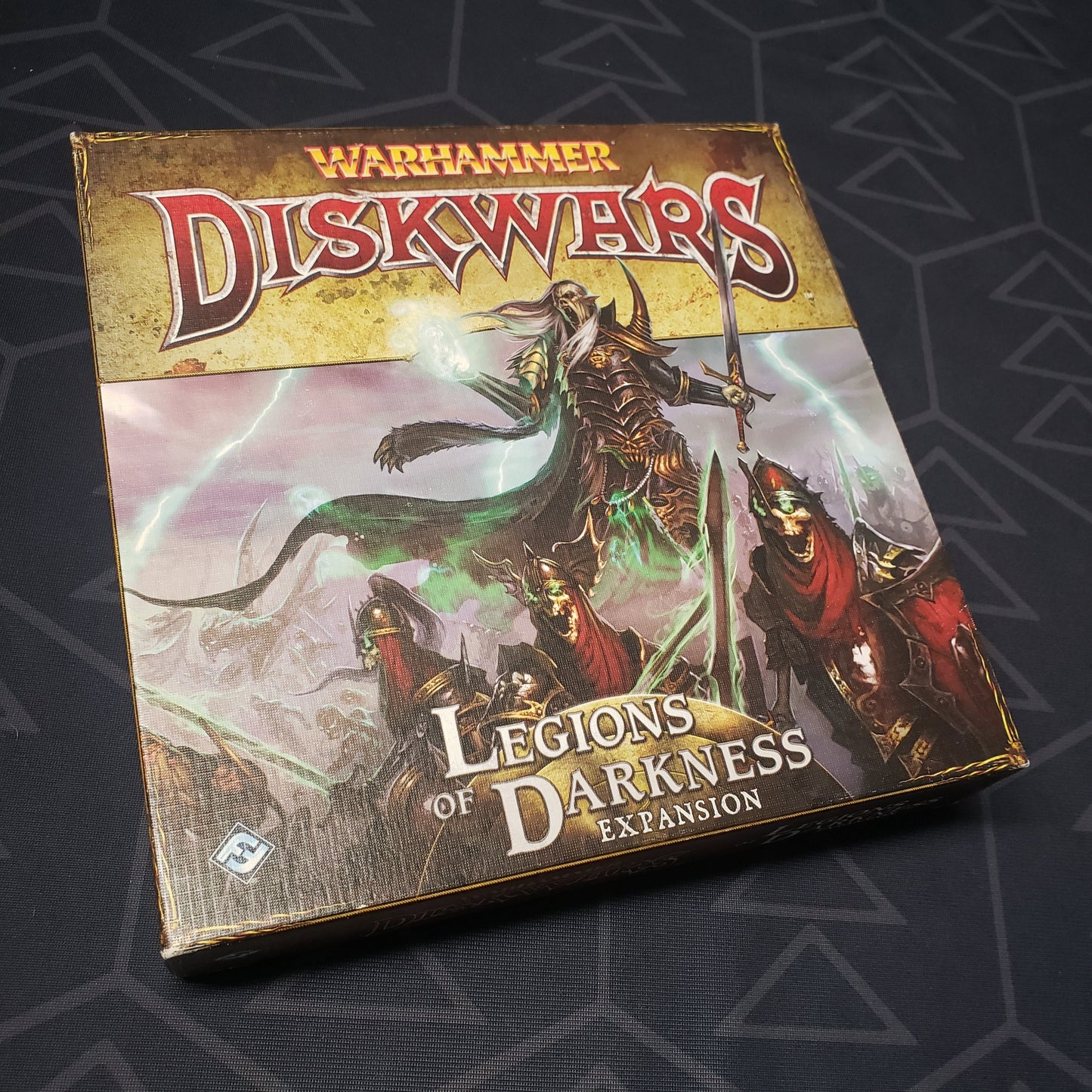 Image shows the front cover of the box of the Legions of Darkness expansion for the board game Warhammer Diskwars