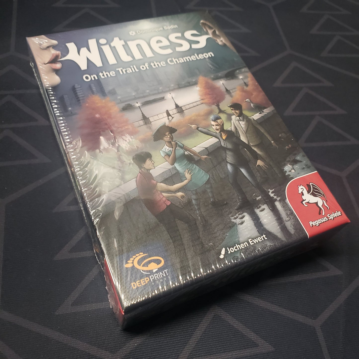 Image shows the front cover of the box for the Witness: On the Trail of the Chameleon board game