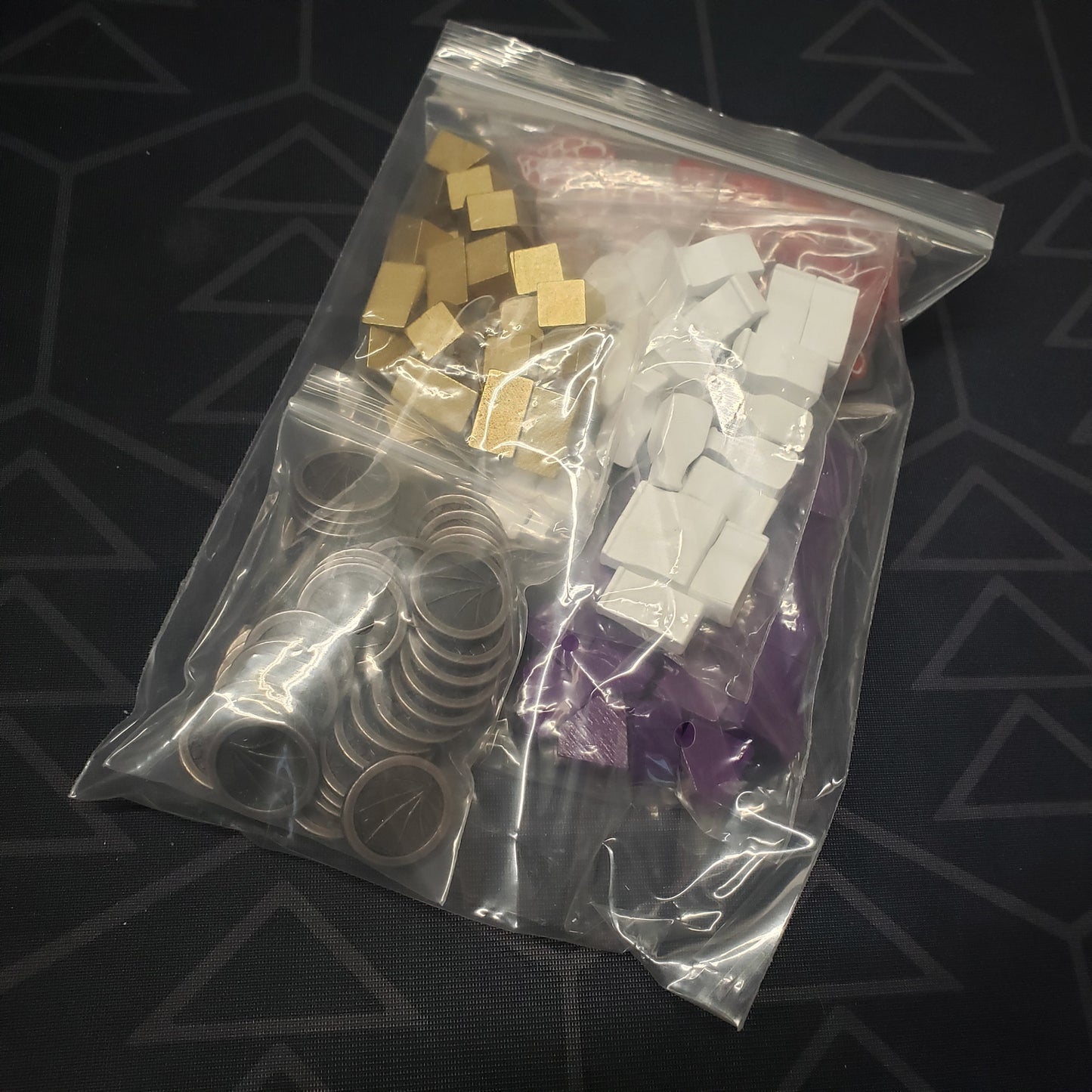 Image shows a ziploc bag full of the deluxe upgraded components for the board game Wyrmspan