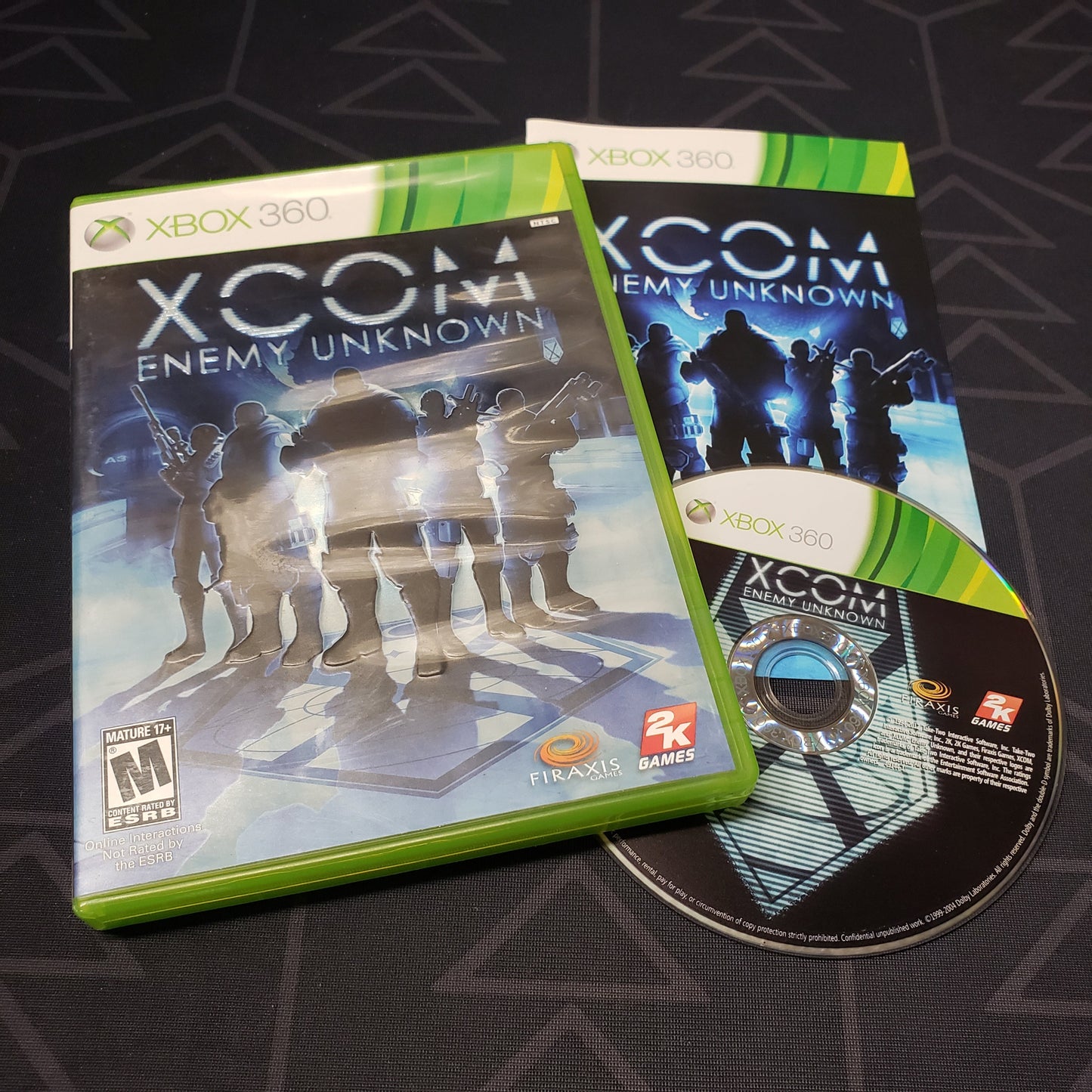 Image shows the case, manual and disc for the video game XCOM: Enemy Unknown for Xbox 360
