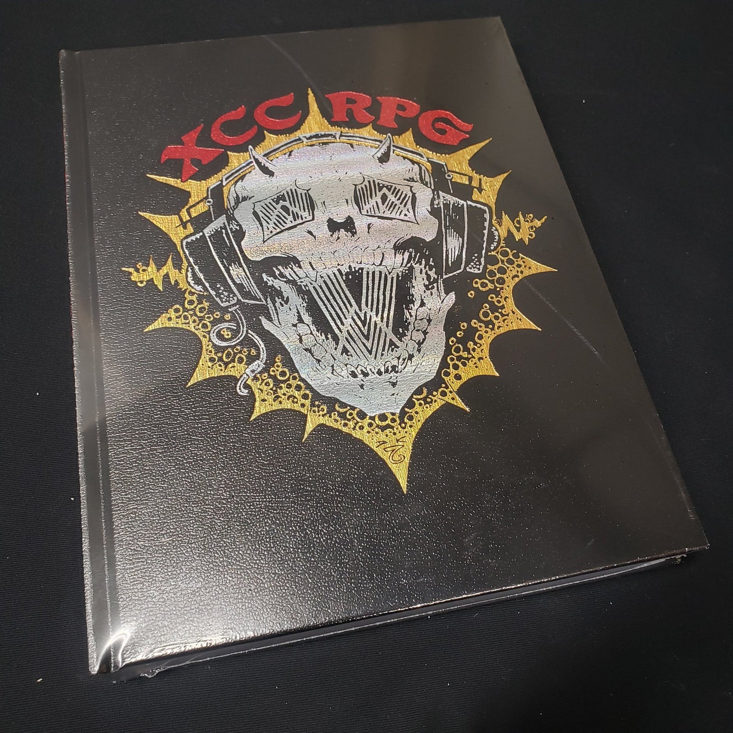 Image shows the front cover of the DJ Skull edition of the Xcrawl Classics core rules roleplaying game book