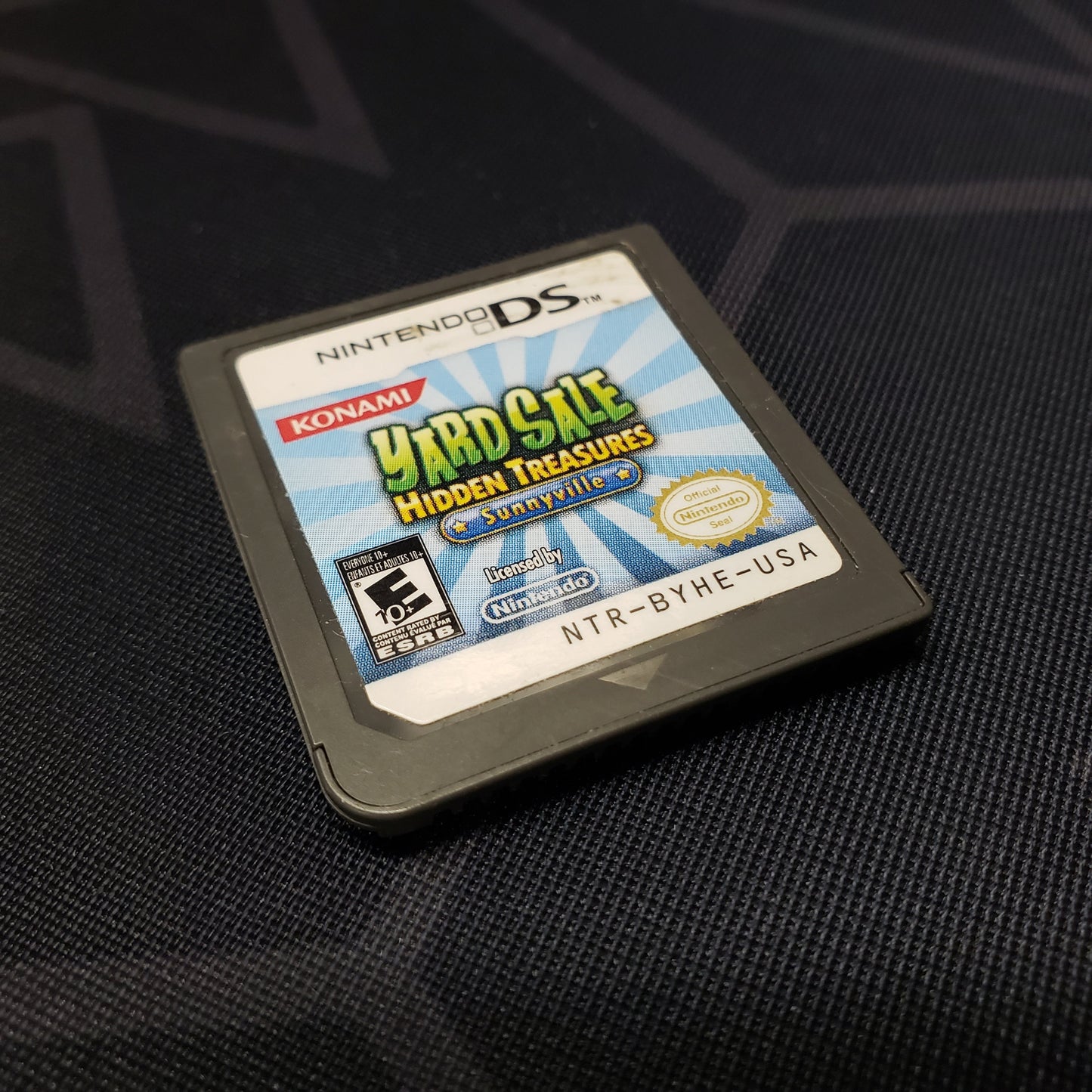 Image shows the front of the cartridge for the video game Yard Sale Hidden Treasures: Sunnyville for Nintendo DS