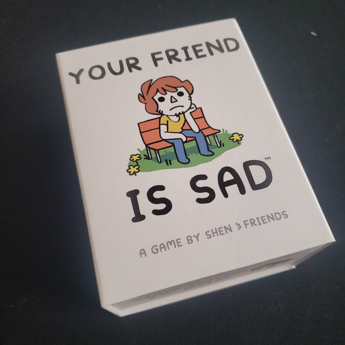 Image shows the front cover of the box of the Your Friend Is Sad card game