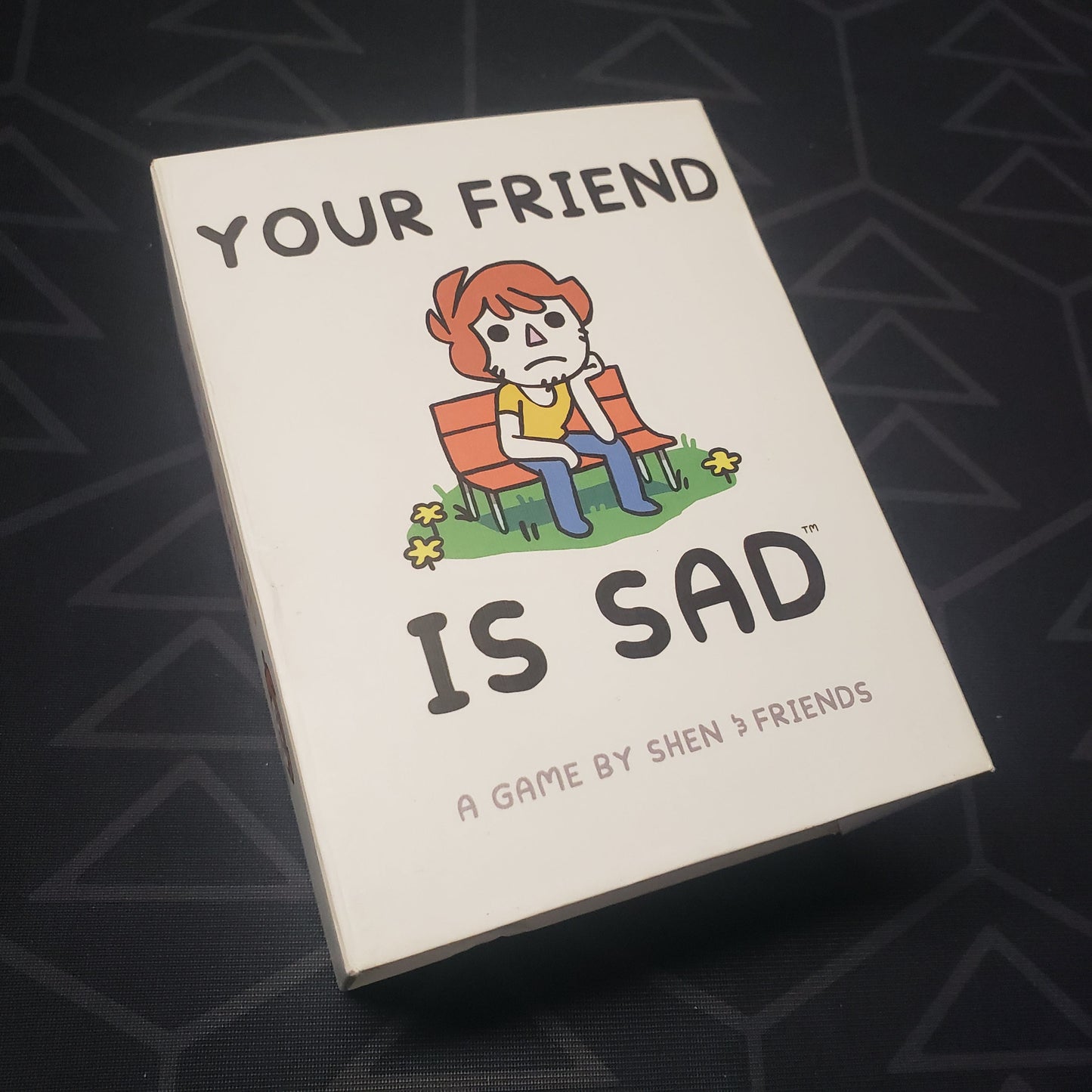Image shows the front cover of the box of the Your Friend Is Sad card game