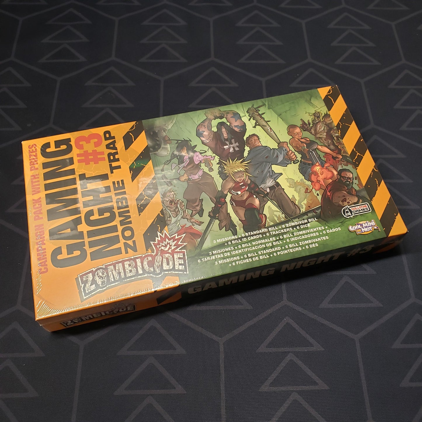 Image shows the front cover of the box of the Gaming Night #3: Zombie Trap expansion for the board game Zombicide