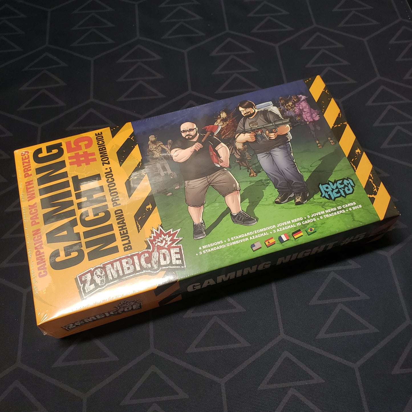 Image shows the front cover of the box of the Gaming Night #5: Bluehand Protocol expansion for the board game Zombicide