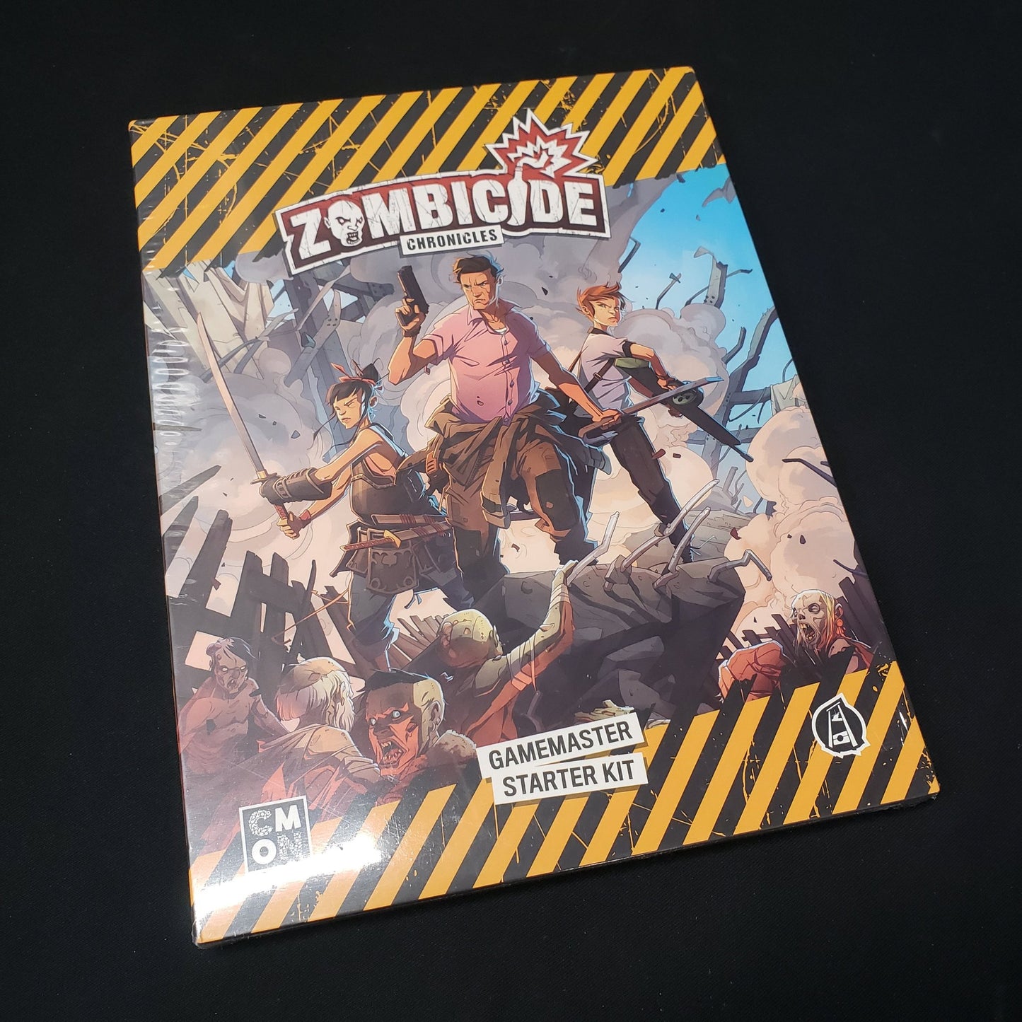 Image shows the front of the packaging of the Gamemaster Starter kit for the roleplaying game Zombicide Chronicles
