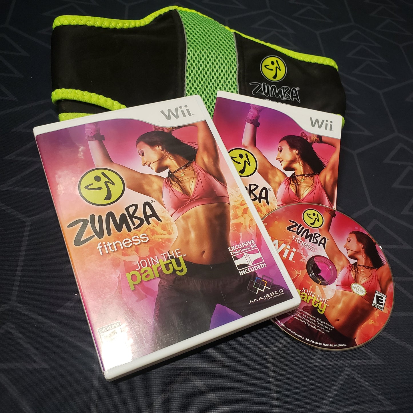 Image shows the case, manual, controller strap and disc for the video game Zumba Fitness for Nintendo Wii