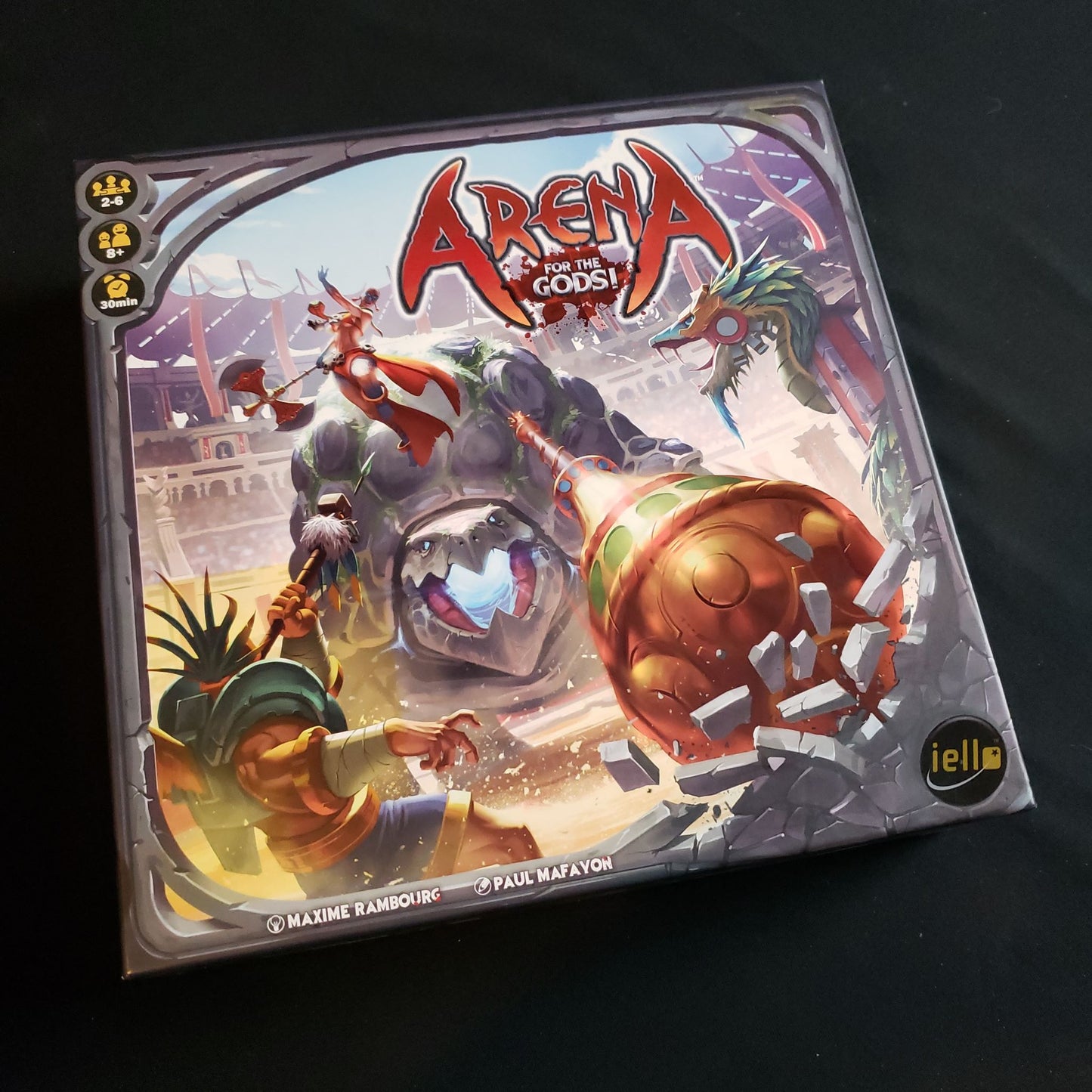 Image shows the front cover of the box of the Arena: For the Gods! board game