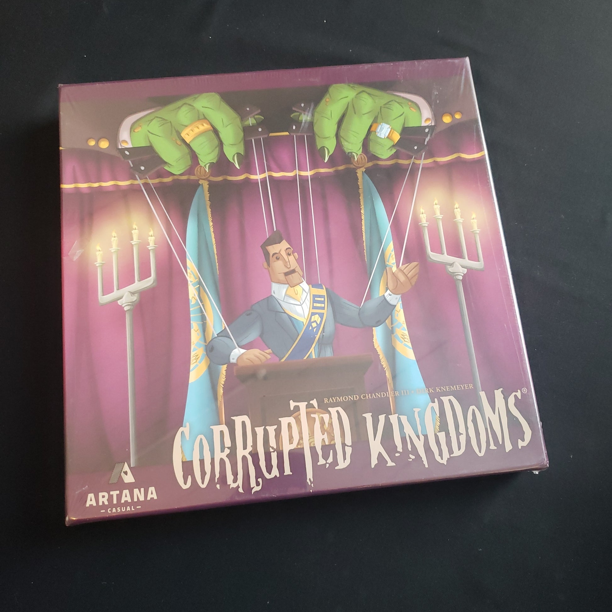 Image shows the front cover of the box of the Corrupted Kingdoms board game
