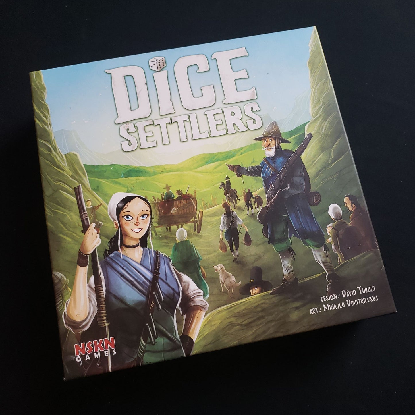 Image shows the front cover of the box of the Dice Settlers board game