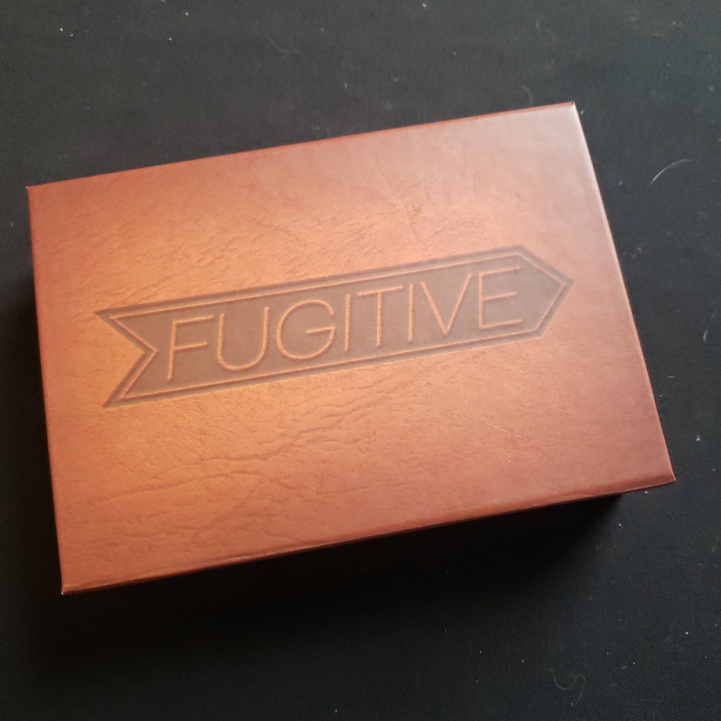 Image shows the front cover of the box of the Fugitive card game