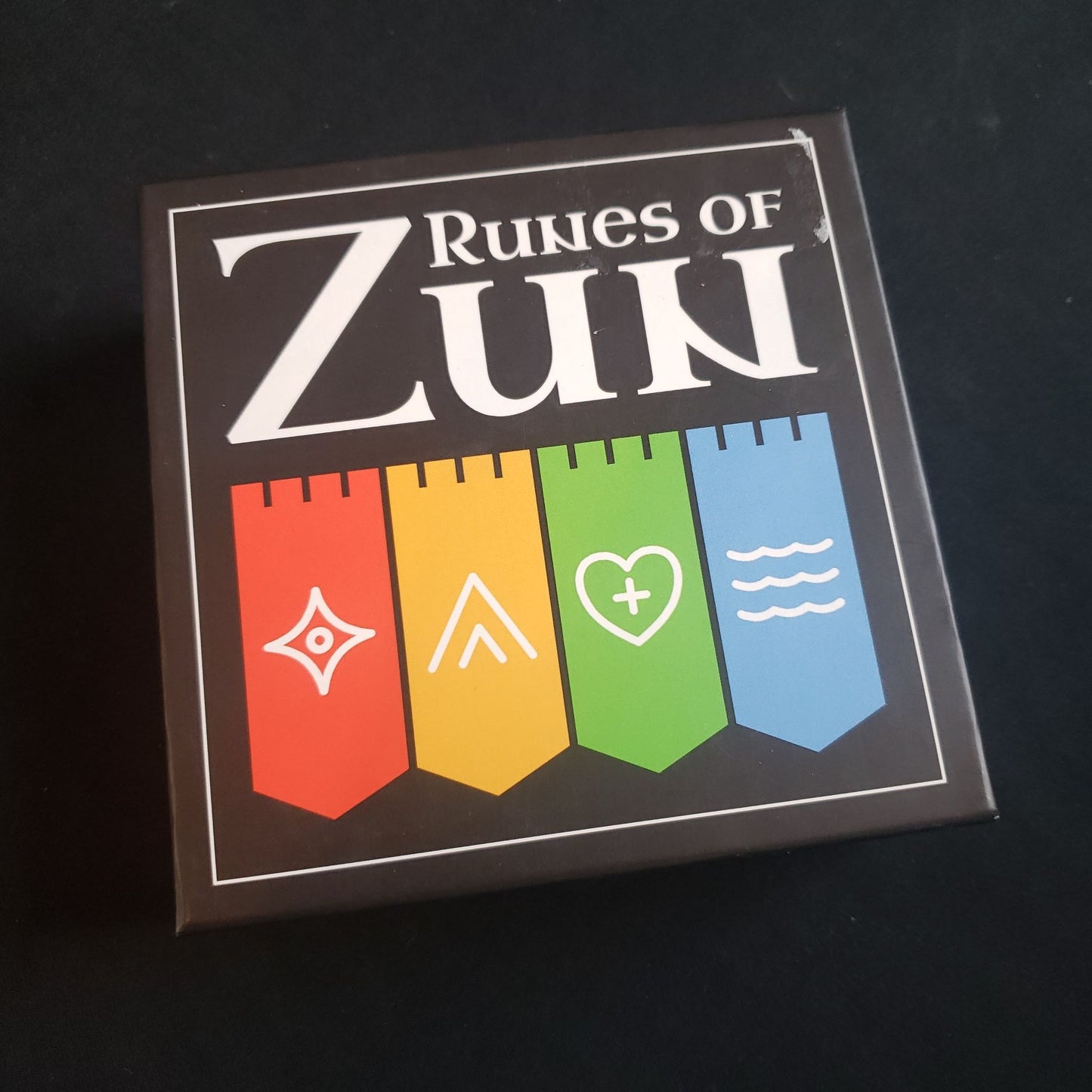 Image shows the front cover of the box of the Runes Of Zun card game
