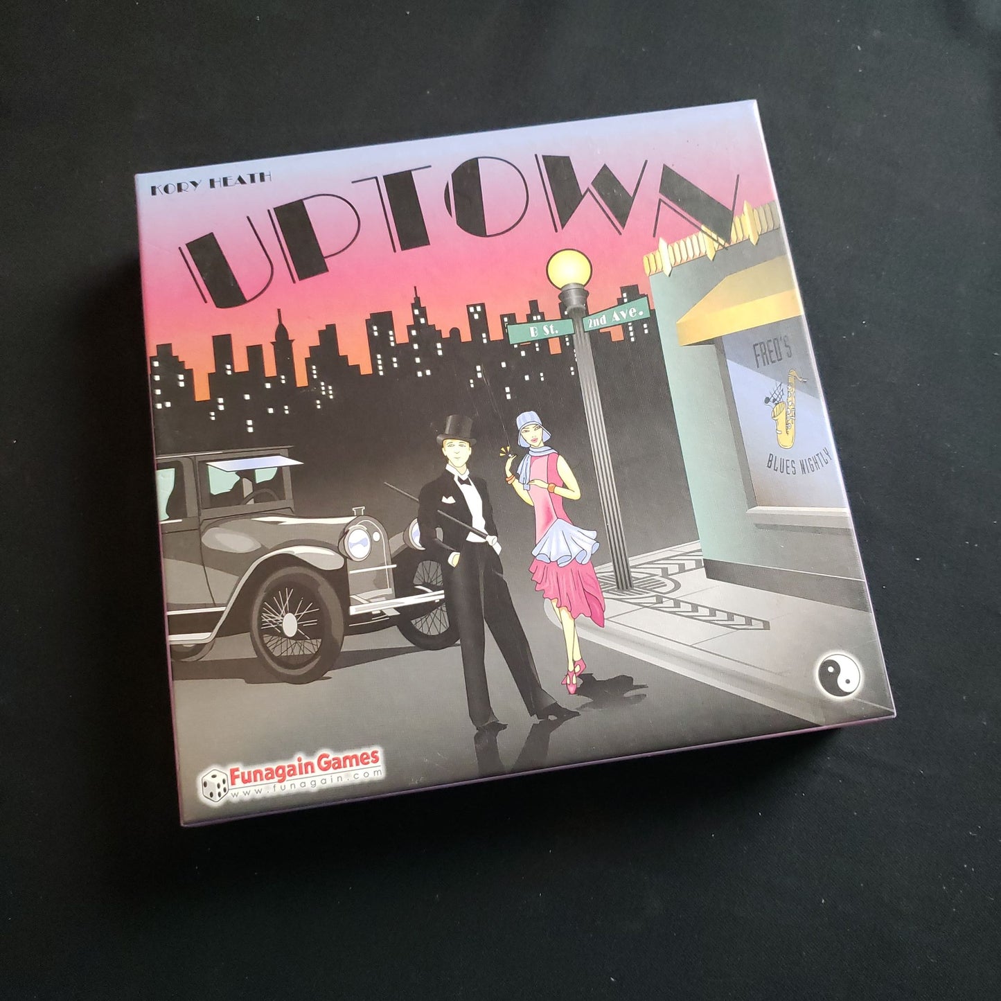Image shows the front cover of the box of the Uptown board game