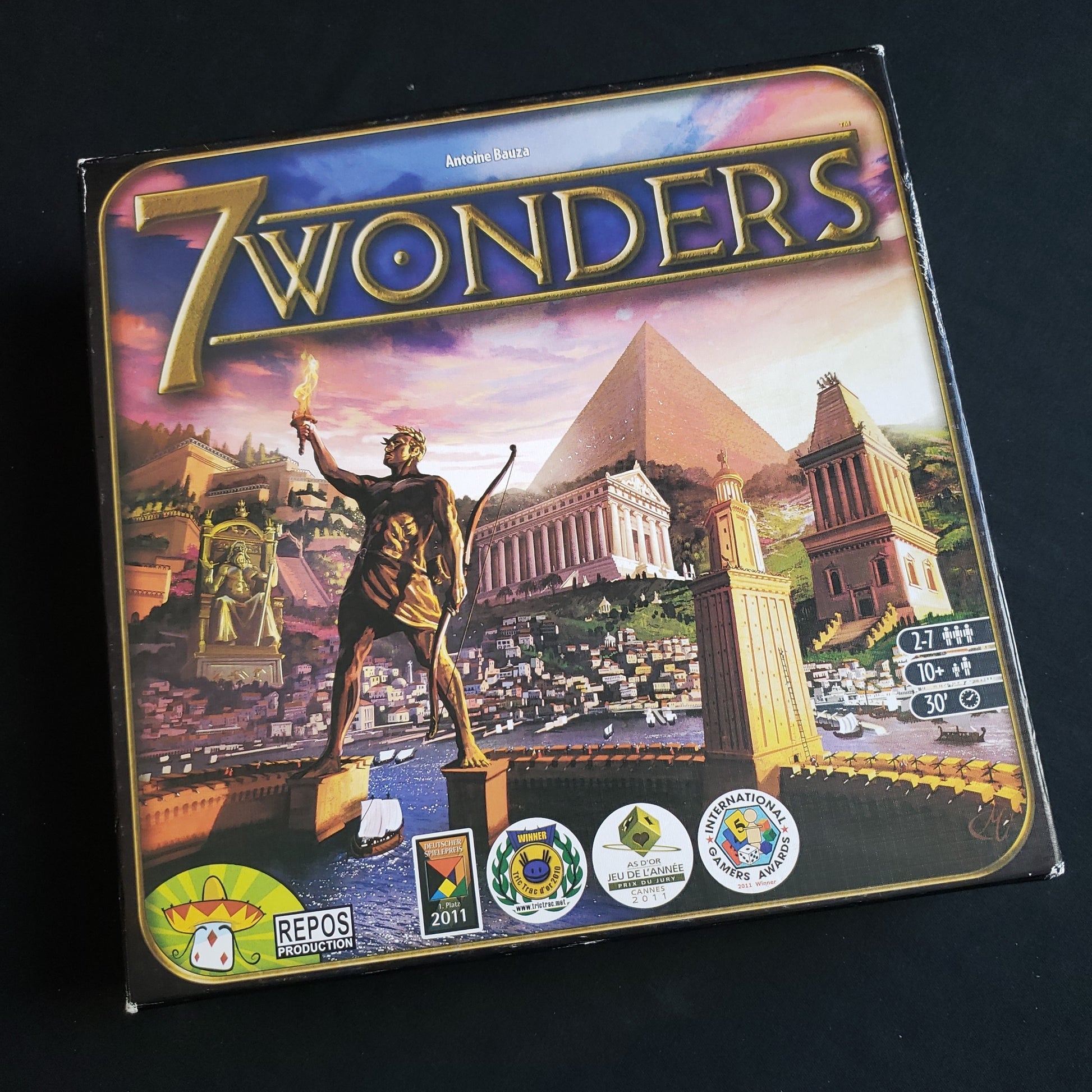 Image shows the front cover of the box of the 7 Wonders board game