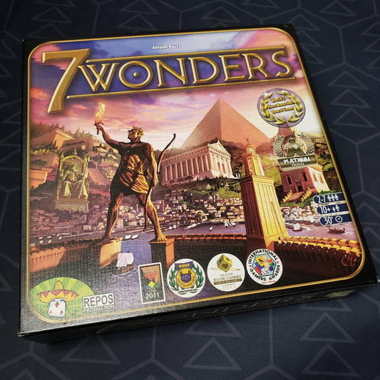 Image shows the front cover of the box of the 7 Wonders board game