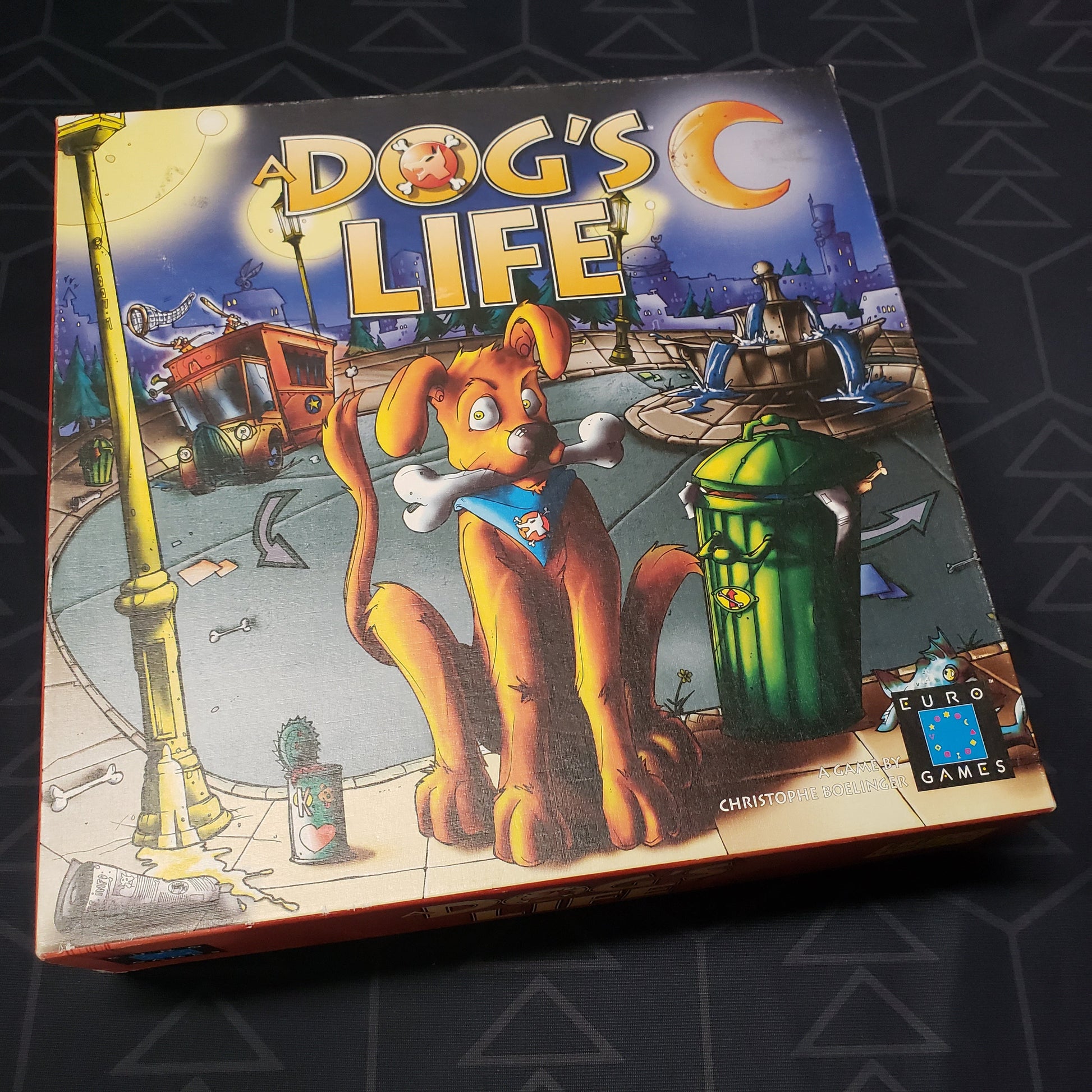 Image shows the front cover of the box for the board game A Dog's Life