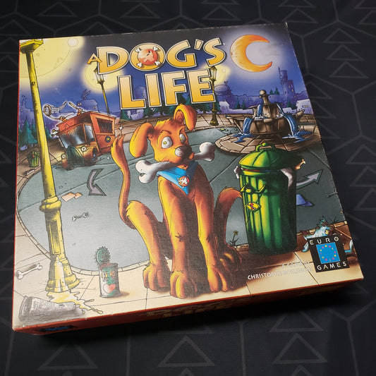 Image shows the front cover of the box for the board game A Dog's Life