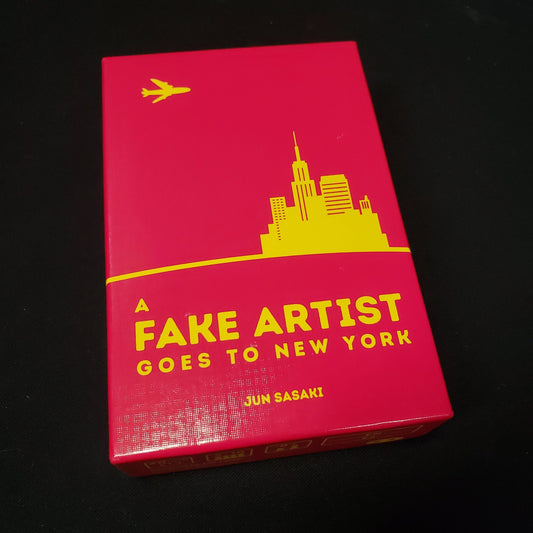 Image shows the front cover of the box of the board game A Fake Artist Goes to New York