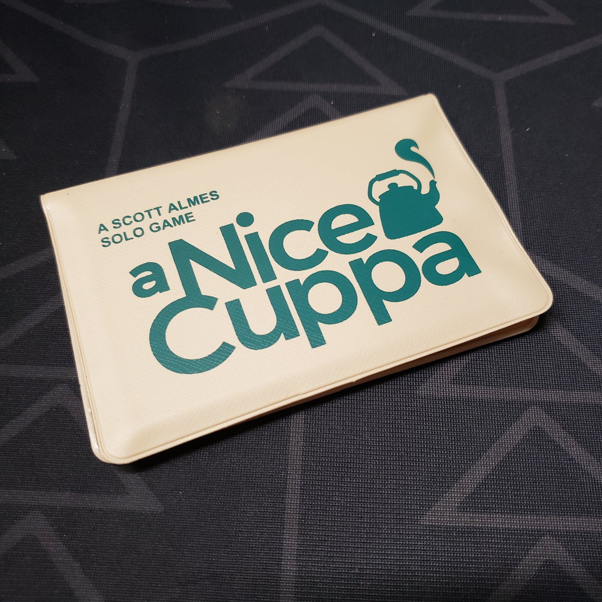 Image shows the front of the card wallet for the card game A Nice Cuppa