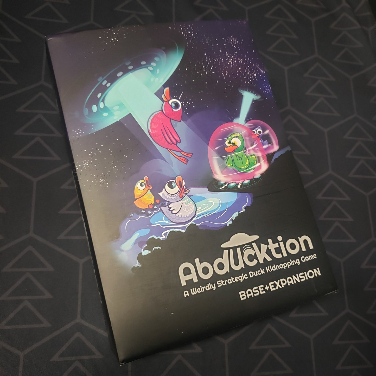 Image shows the front cover of the box for the Abducktion (Base + Expansion Edition) board game