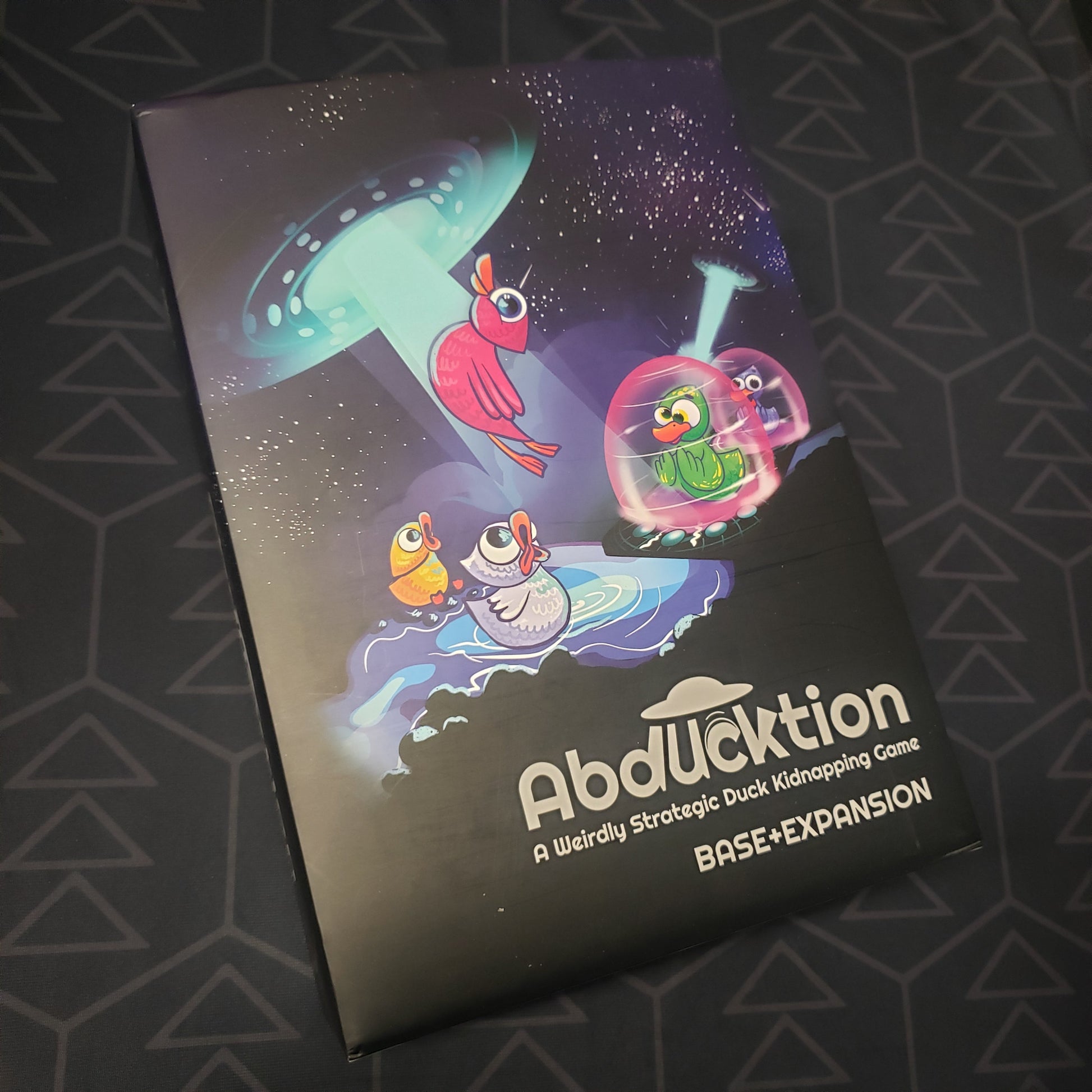 Image shows the front cover of the box for the Abducktion (Base + Expansion Edition) board game