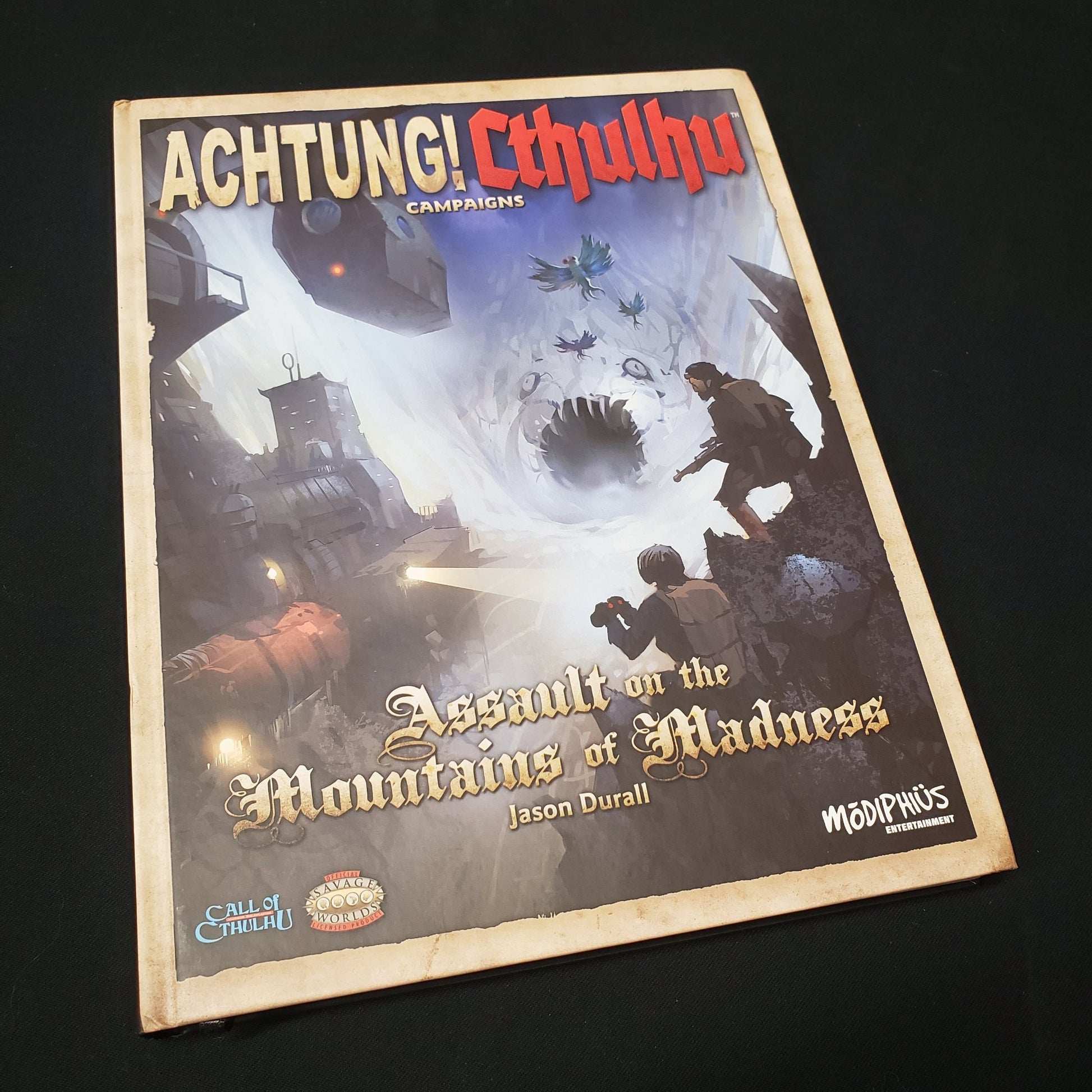 Image shows the front cover of the Assault on the Mountains of Madness book for the roleplaying game Achtung! Cthulhu