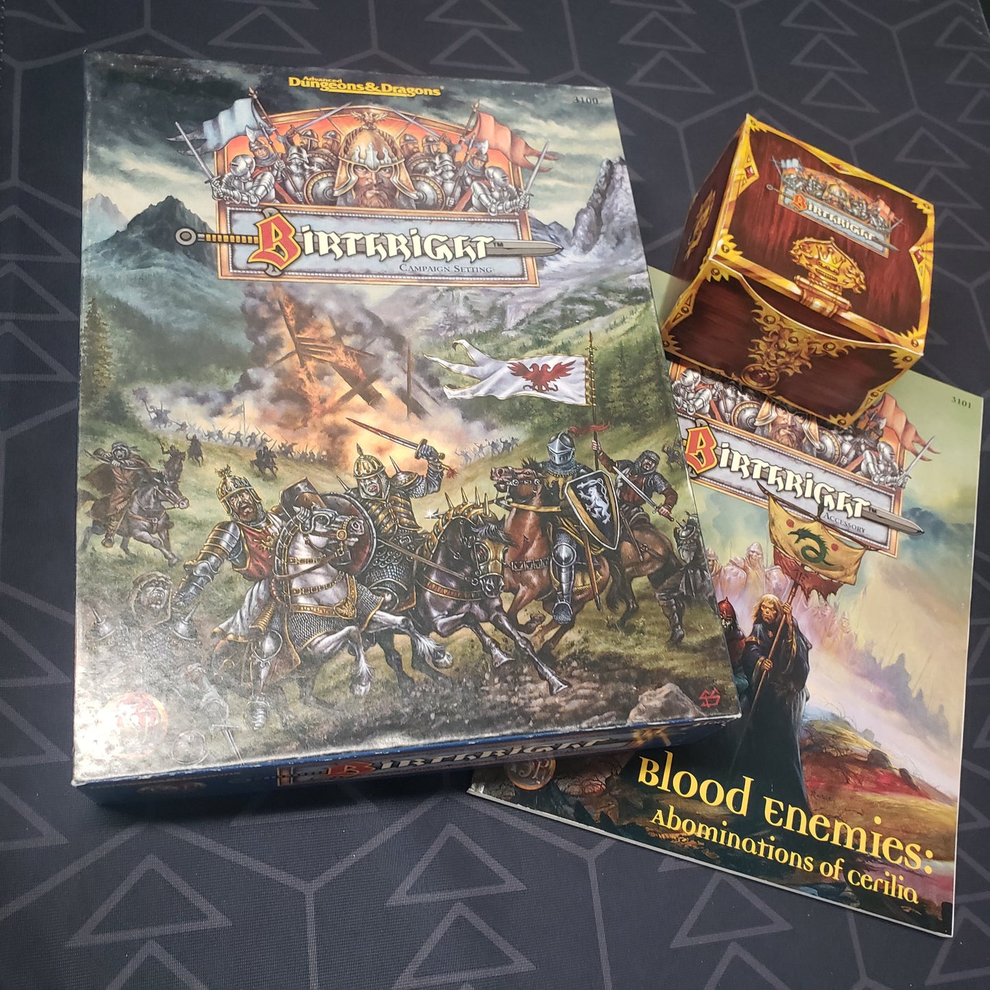 Image shows the front cover of the Birthright Campaign Setting box for the roleplaying game Advanced Dungeons & Dragons 1E, along with the card box and Blood Enemies book