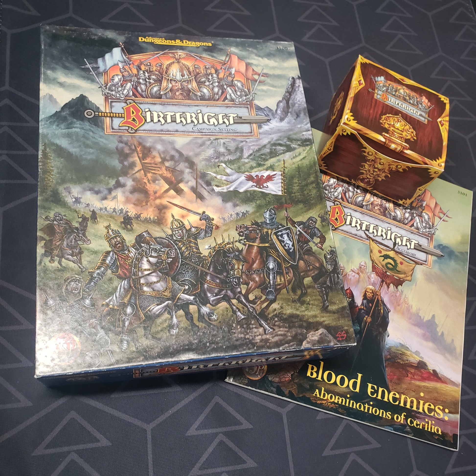 Image shows the front cover of the Birthright Campaign Setting box for the roleplaying game Advanced Dungeons & Dragons 1E, along with the card box and Blood Enemies book