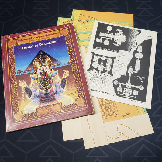 Image shows the front cover of the book for the Desert of Desolation adventure module for the roleplaying game Advanced Dungeons & Dragons: First Edition, with the booklet and map inserts fanned out