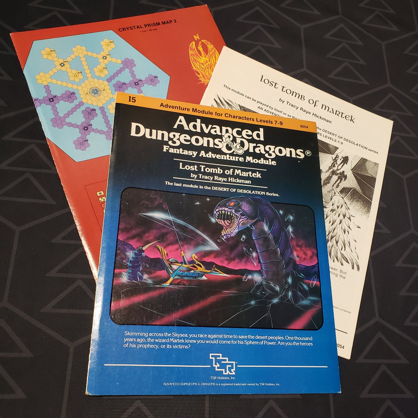 Image shows the front cover of the folio for the Lost Tomb of Martek adventure module for the roleplaying game Advanced Dungeons & Dragons 1E with the booklet & map fanned out