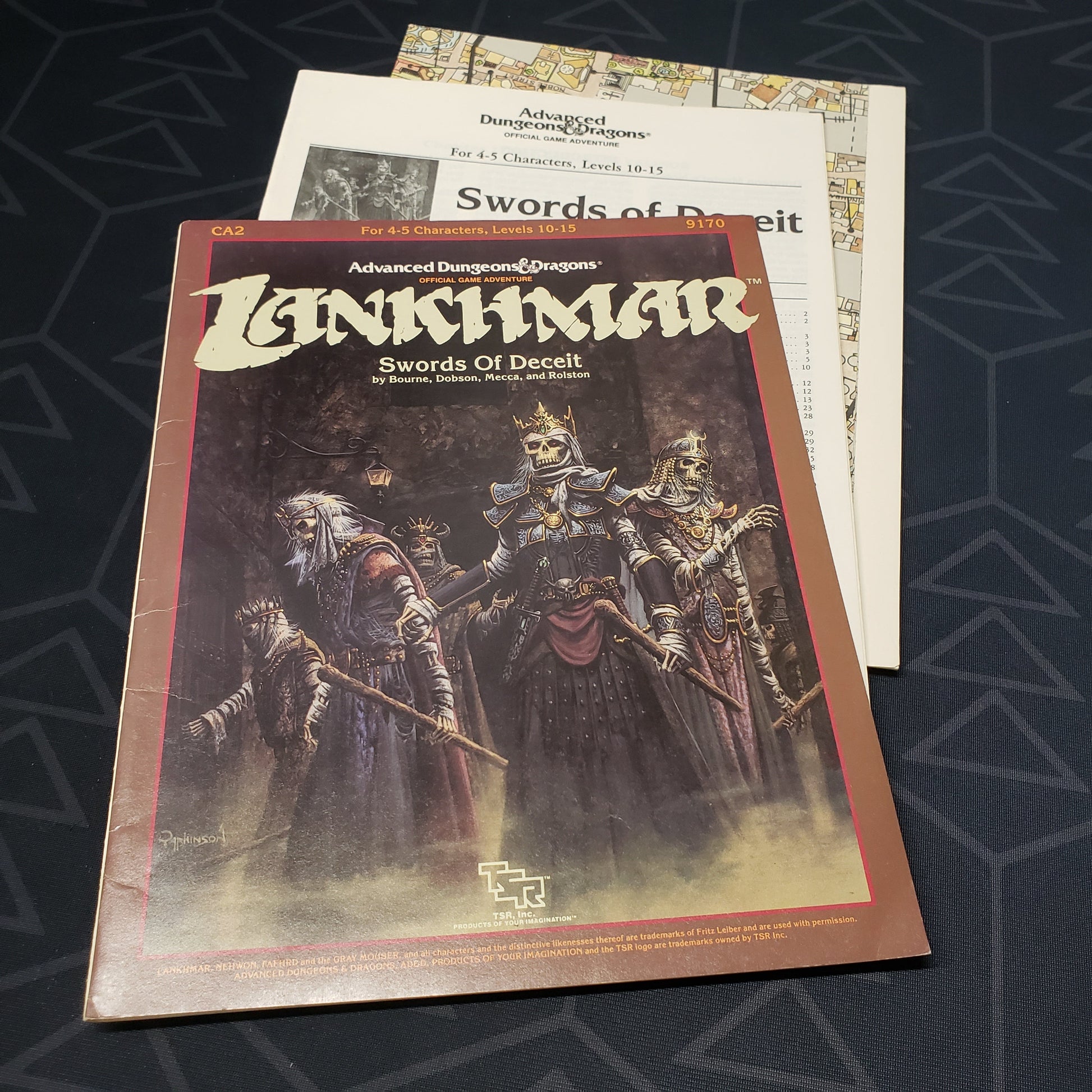 Image shows the front cover of the folio for the Swords of Deceit adventure module for the roleplaying game Advanced Dungeons & Dragons: First Edition, with the booklet and map inserts fanned out