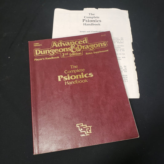 Image shows the front cover of the Complete Psionics Handbook for the roleplaying game Advanced Dungeons & Dragons: Second Edition, sitting on top of the errata sheet