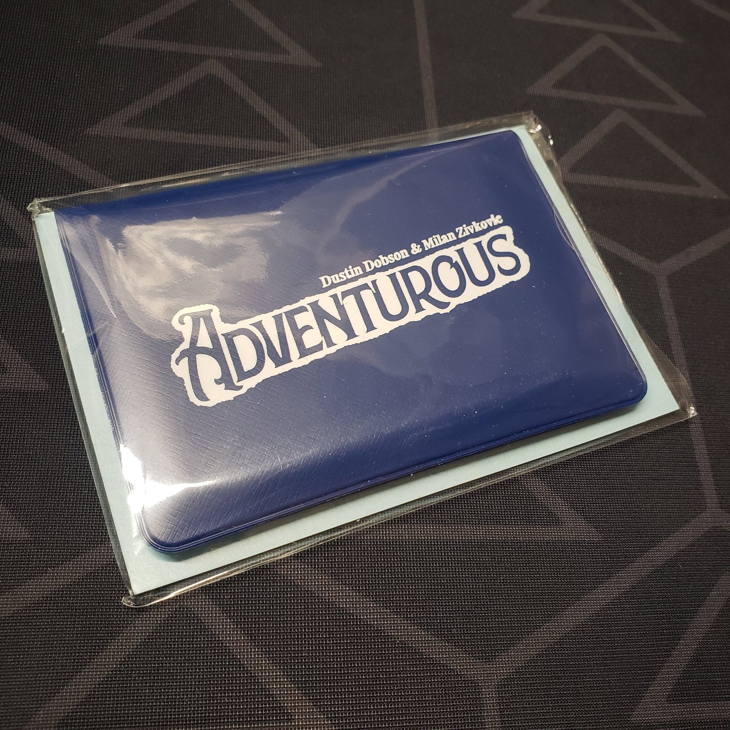Image shows the front of the card wallet for the Adventurous card game