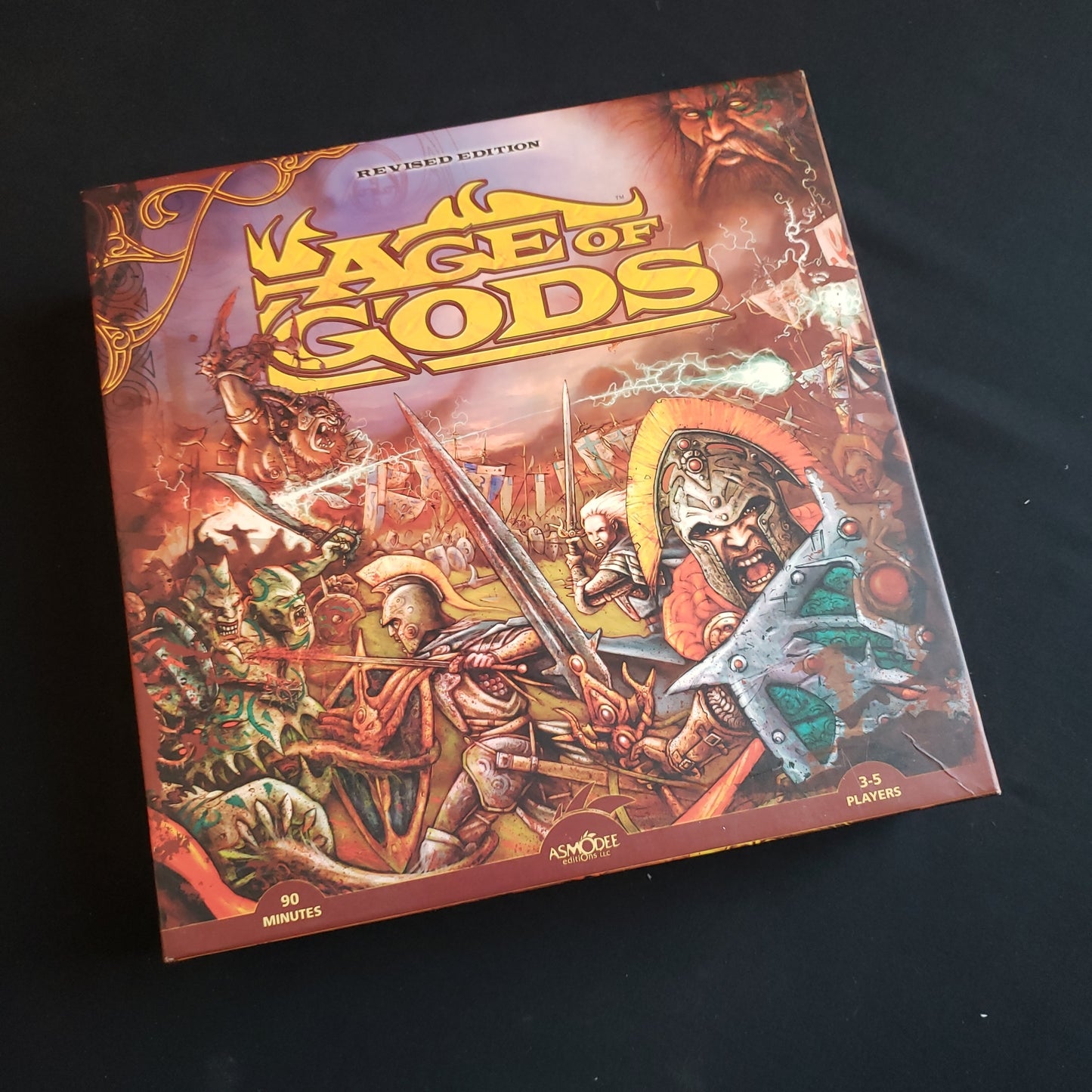 Image shows the front cover of the box of the Age of Gods: Revised Edition board game