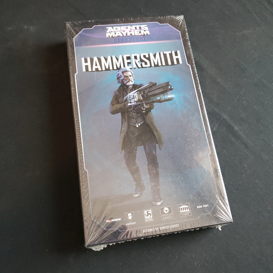 Image shows the front cover of the box of the Hammersmith expansion for the board game Agents of Mayhem
