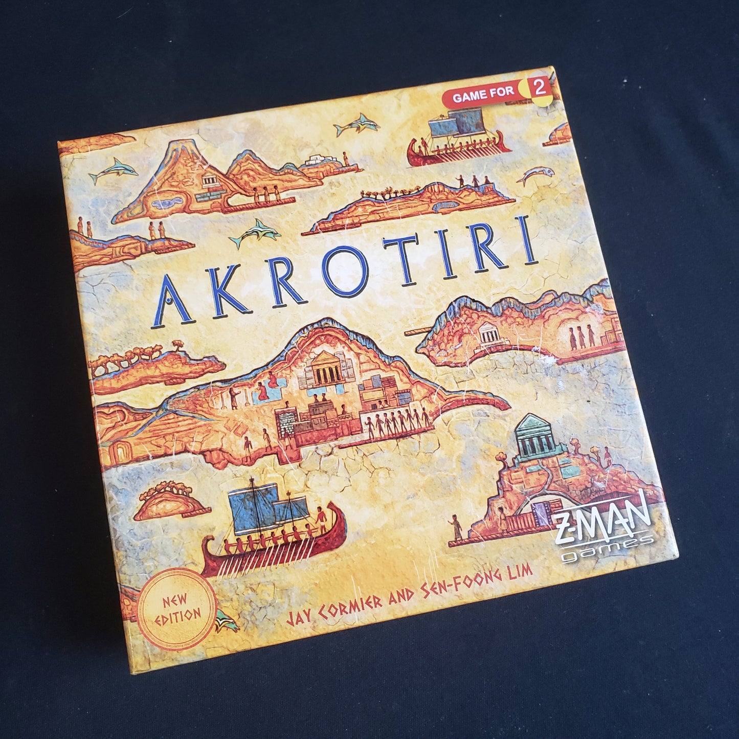 Image shows the front cover of the box of the Akrotiri board game