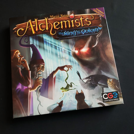 Image shows the front cover of the box of the King's Golem expansion for the board game Alchemists