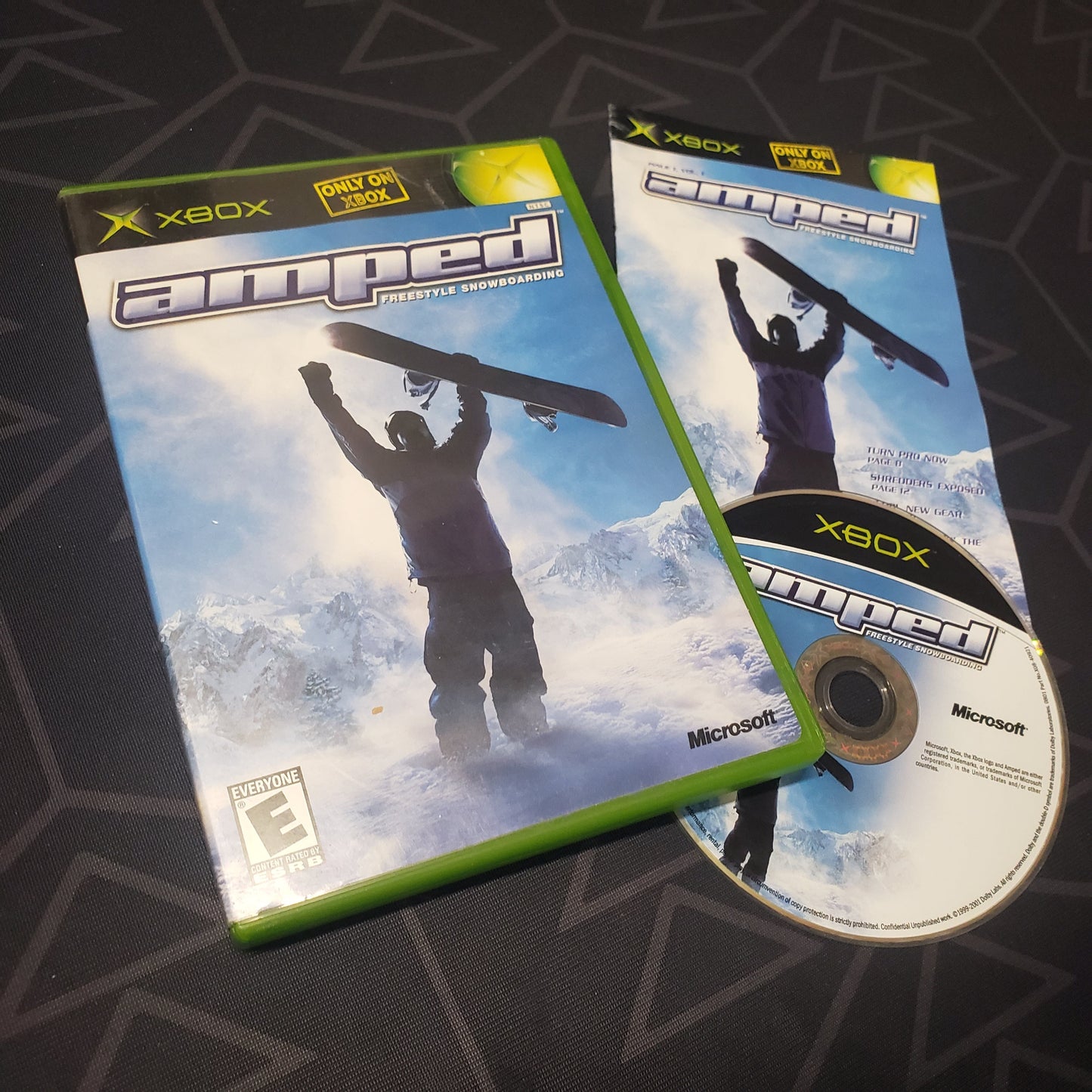 Image shows the case, manual and disc for the video game Amped: Freestyle Snowboarding for the original Xbox