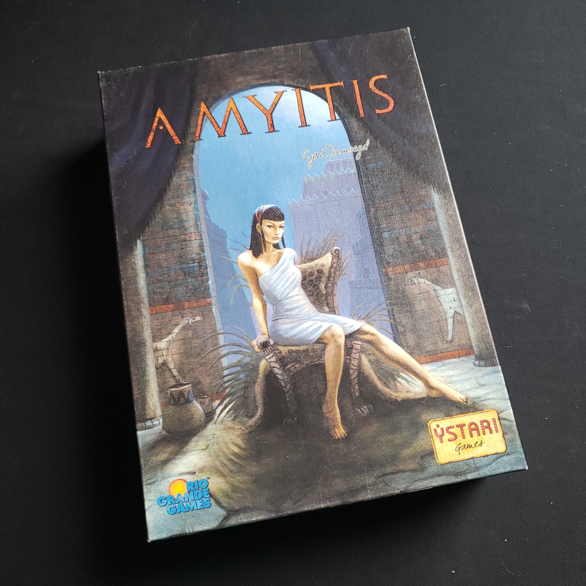 Image shows the front cover of the box of the Amyitis board game