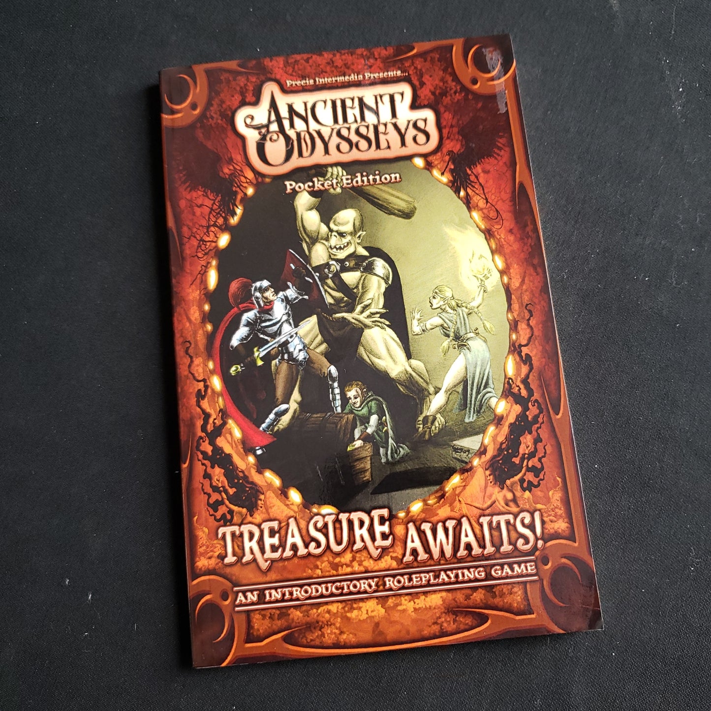 Image shows the front cover of the Ancient Odysseys: Treasure Awaits! Pocket Edition roleplaying game book