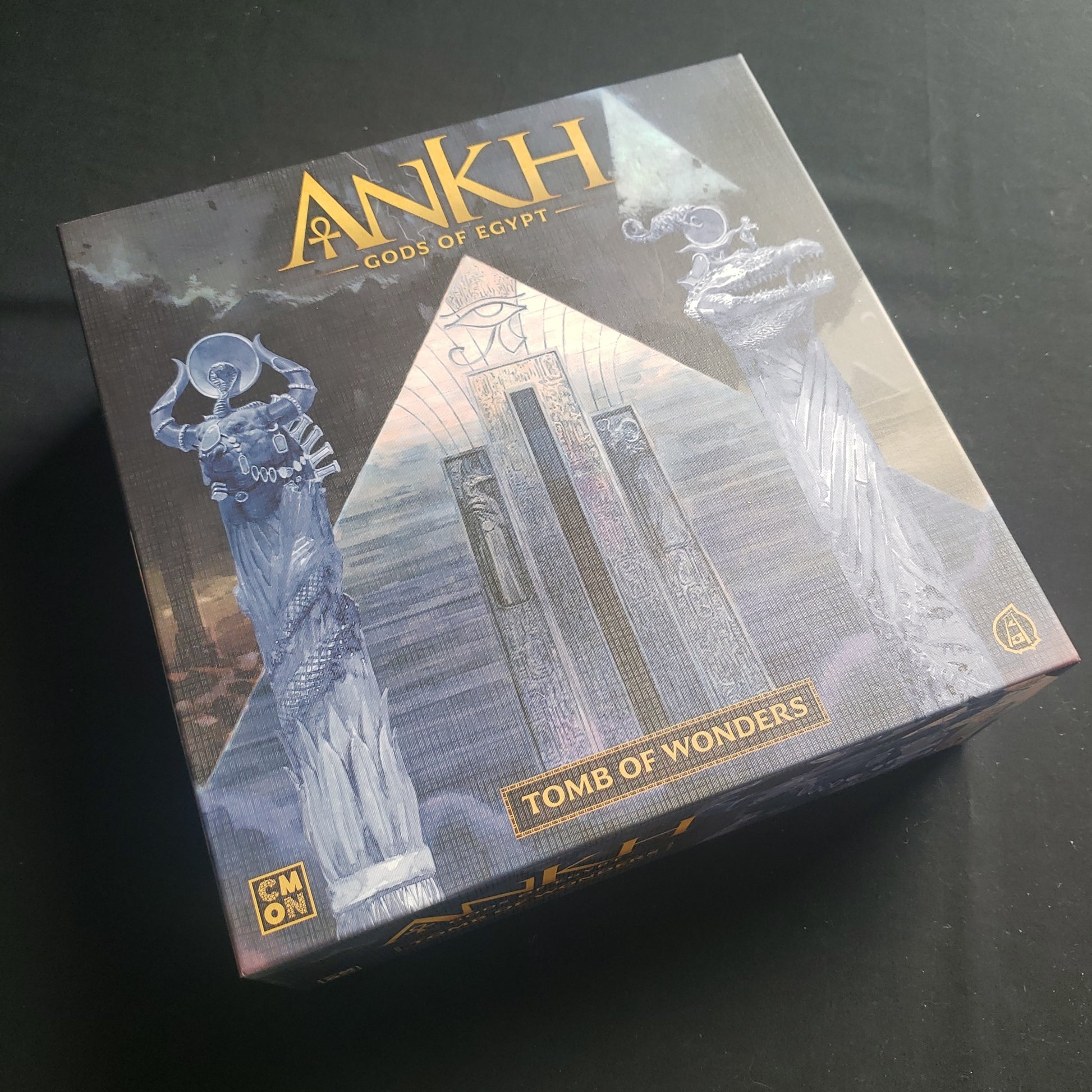 Image shows the front cover of the Tomb of Wonders stretch goals box for the Ankh: Gods of Egypt board game
