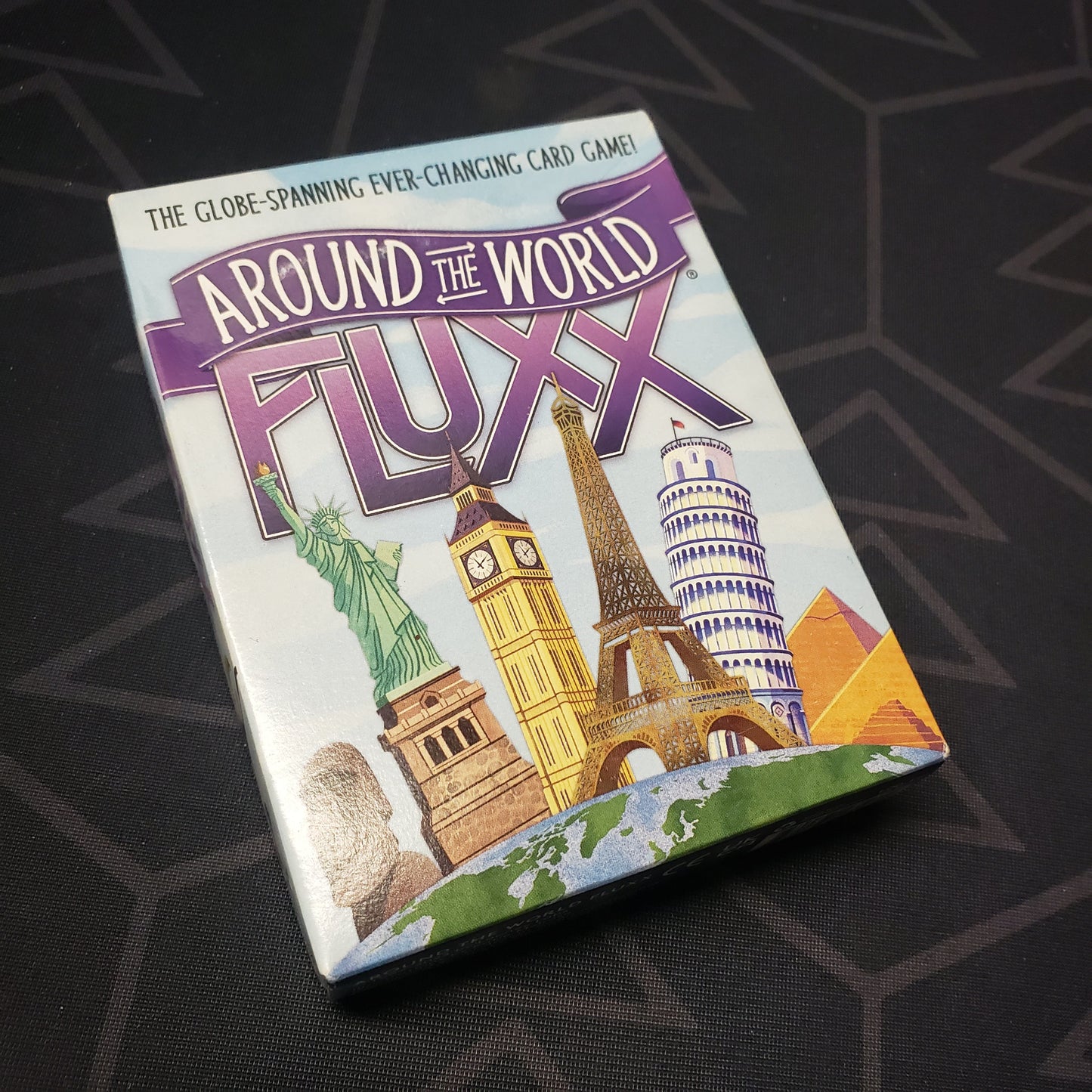 Image shows the front cover of the box for the Around the World Fluxx card game