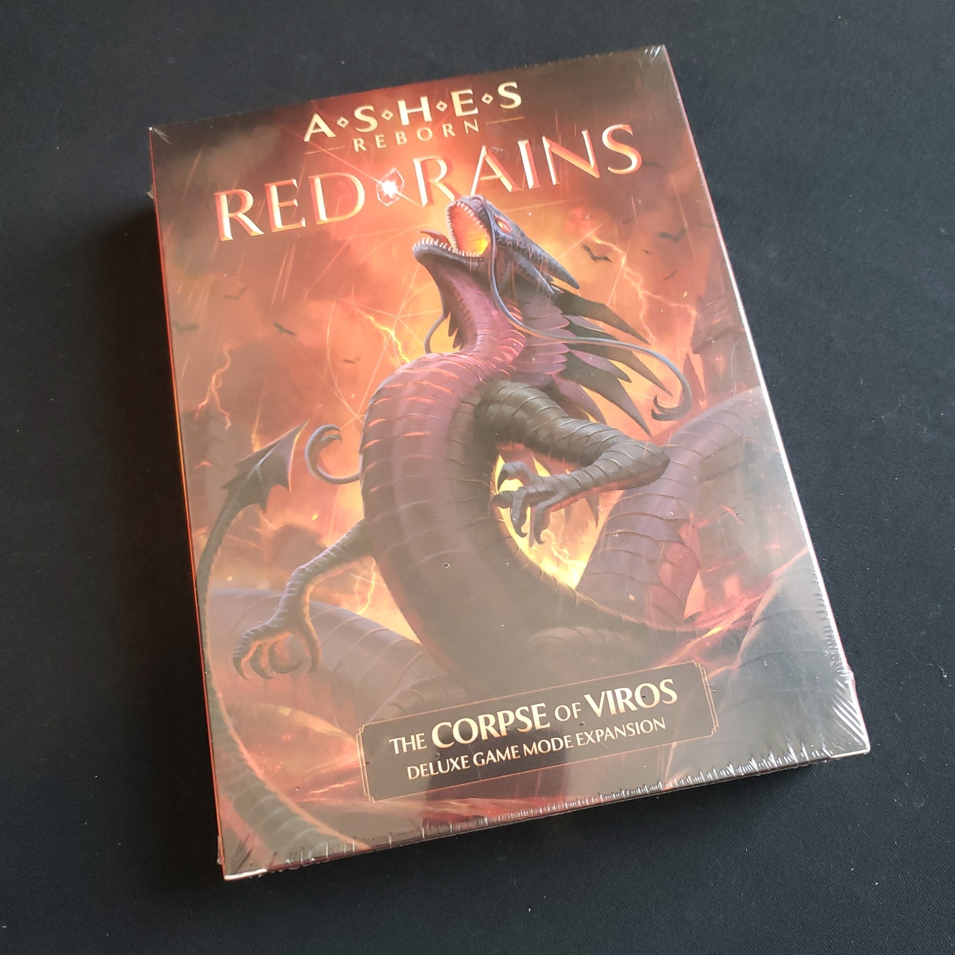 Image shows the front cover of the box of the Red Rains expansion for the card game Ashes Reborn